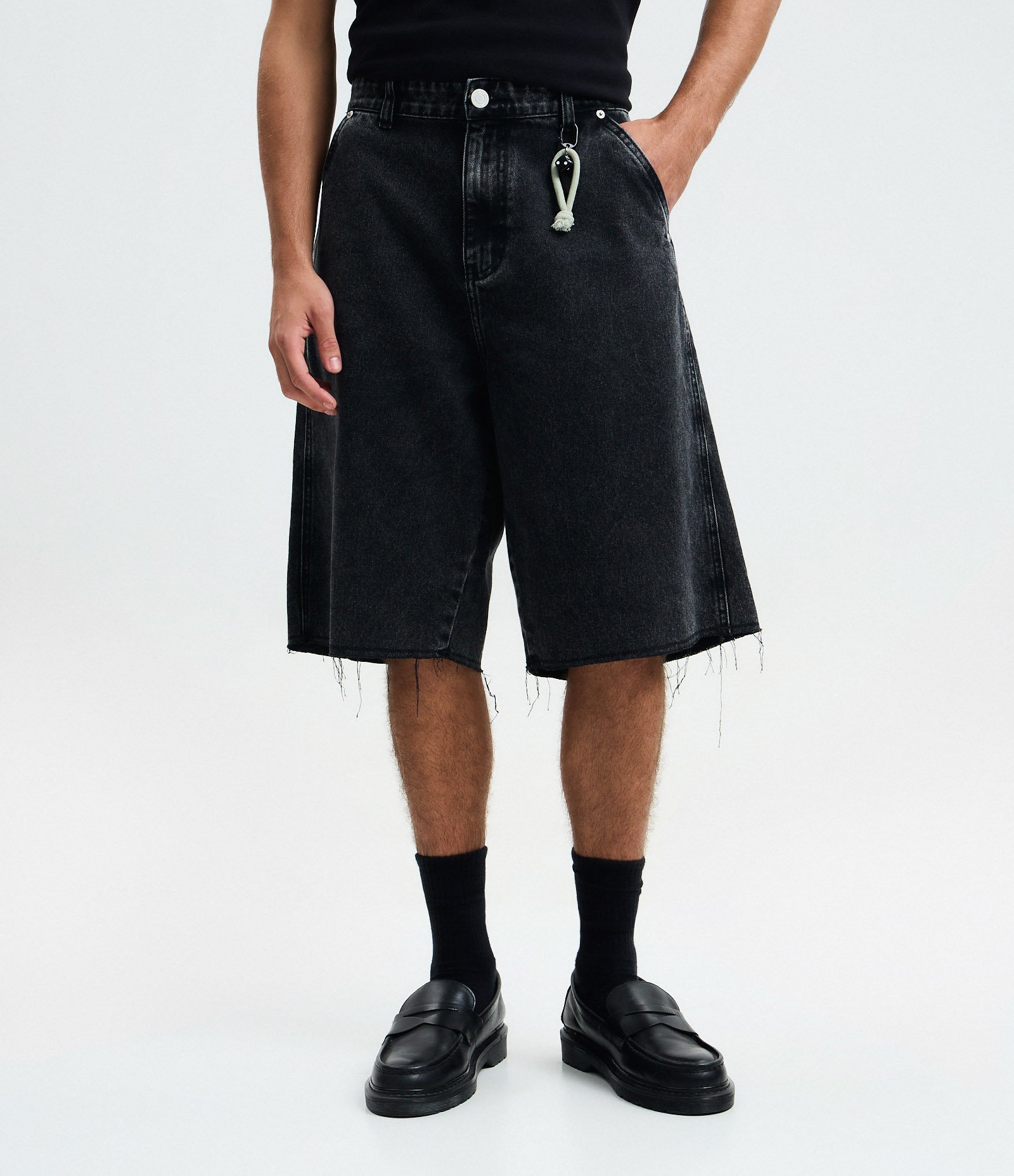 Bermuda Baggy em Jeans com Barra Desfiada e Detalhe com Cordão Preto